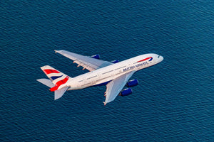 An aerial view of a British Airways airplane flying over a body of water.