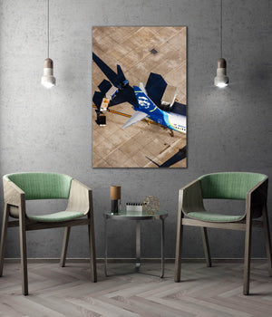 a modern living room with a large wall-mounted artwork depicting an airplane on a tiled floor. The room is furnished with two green chairs, and a small table is placed between them. The overall design and decor create a contemporary and stylish atmosphere.