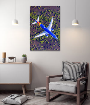 a large airplane flying over a forested area, with a minimalist and modern interior design in the background.