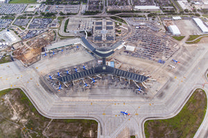 An aerial view of an airport with multiple runways, terminals, and parked airplanes.