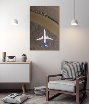 a large airplane flying over a desert landscape, with a minimalist and modern interior design in the background.
