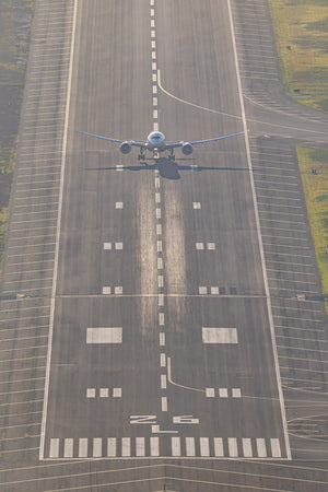 An aerial view of a large airplane on a runway, preparing for takeoff.