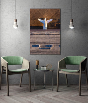 a modern living room with a large abstract painting hanging on the wall, two green chairs, and a small table with a glass top.