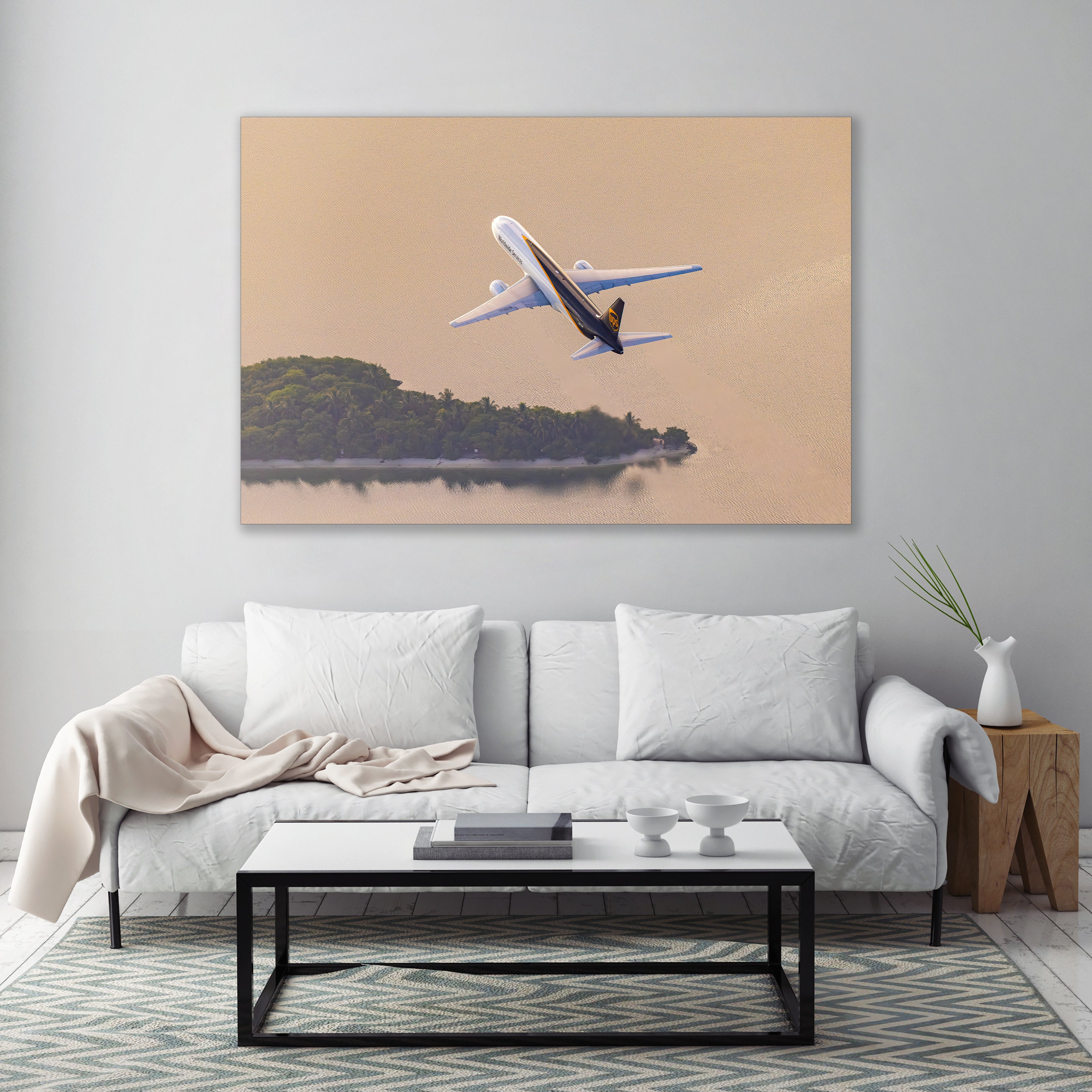 a large, framed photograph of a white airplane flying over a body of water, with a serene landscape in the background.