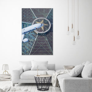 a large American Airlines airplane flying over a city skyline, with a modern glass and steel building in the background.