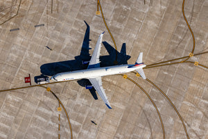An aerial view of an airport runway with a large commercial airplane parked on the tarmac.