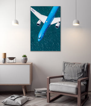 a large blue airplane flying over a body of water, with a minimalist and modern interior design in the background.