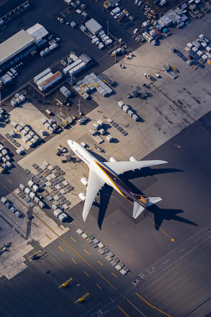An aerial view of an airport tarmac with a large passenger jet parked on the runway.