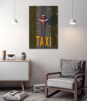 a large wall art piece depicting an airplane taxiing on a runway, with the word "TAXI" prominently displayed.