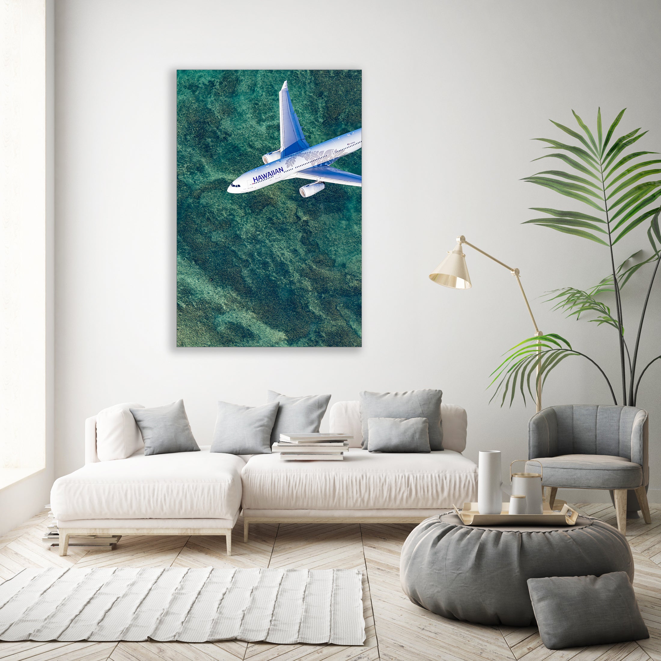 a large white sofa with a coffee table in a modern living room, featuring a large wall art piece of a blue and white airplane flying over a green ocean.